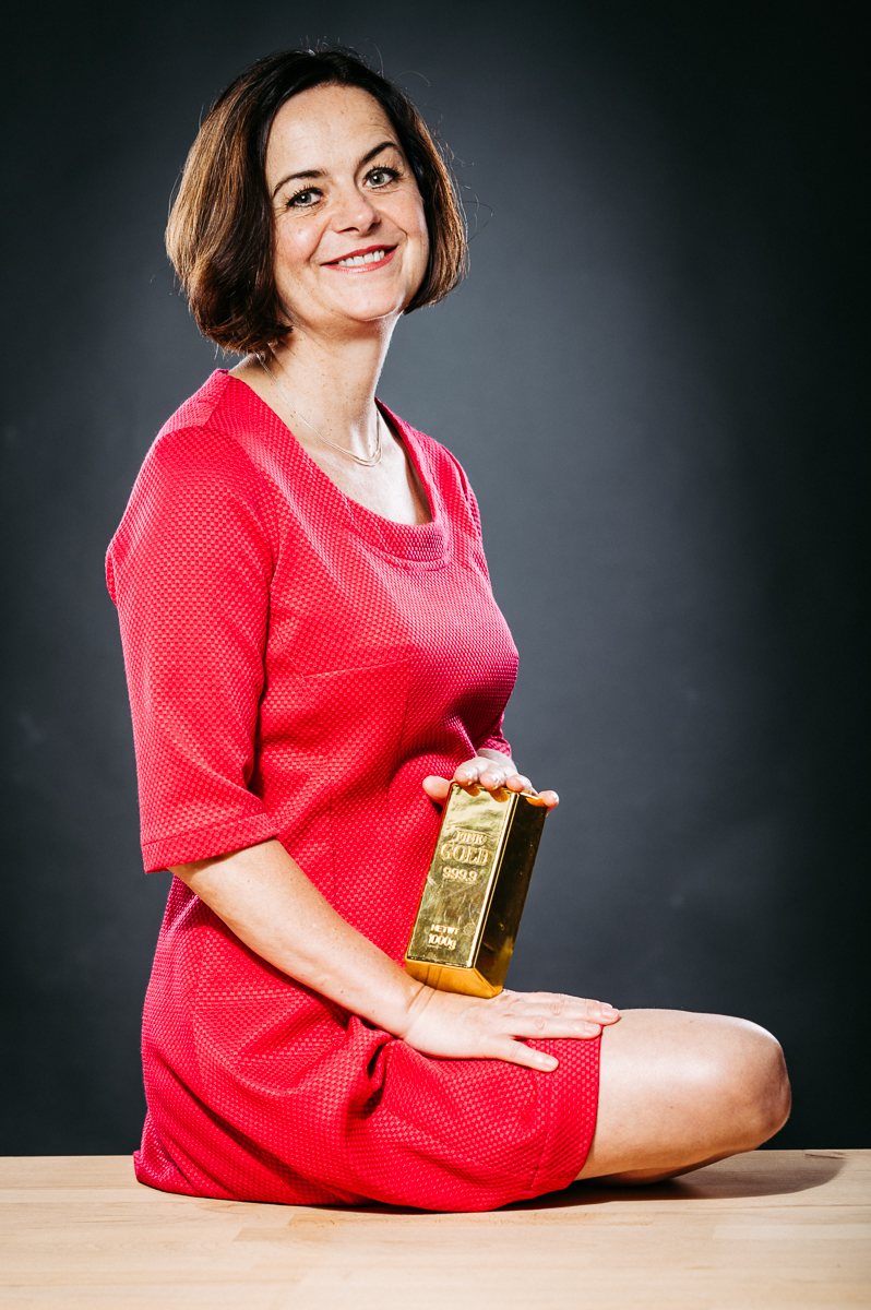 Ute Wagner hält einen Goldbarren in den Händen